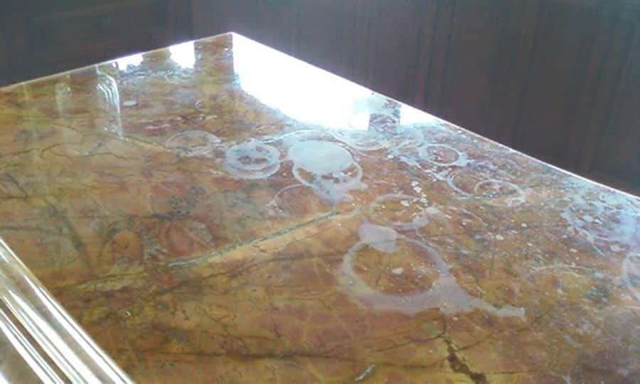 Stained marble countertop in a kitchen with poor lighting